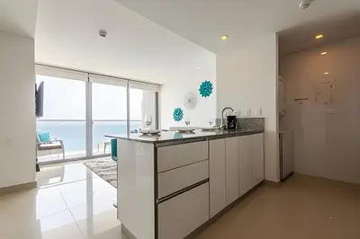 a kitchen with white cabinets and a large window at Vista al Mar y Centro Histórico “Morros City” 26fl in Cartagena de Indias