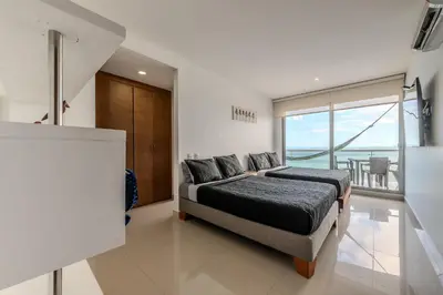 a bedroom with a bed and a view of the ocean at Piso 24 vista al mar 2BR in Cartagena de Indias