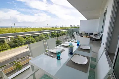 a white dining room with a view of the ocean at Apto en Morros Epic Cartagena in Cartagena de Indias