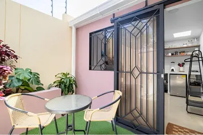a room with a table and chairs and a door at Lindo apto cerca del Malecón con patio y terraza in Barranquilla