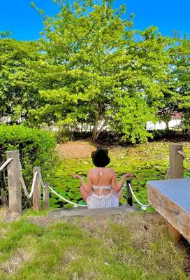 a woman sitting on a fence in a park at Cerca a Coveñas- Cabaña El Paraiso - Mar - Arena in San Antero
