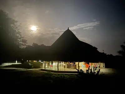 a building with a straw roof with the moon in the sky at La Felicidá in Cartagena de Indias