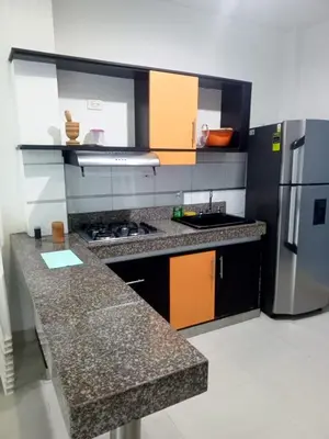 a kitchen with granite counter tops and a refrigerator at Condominio de Cabañas Cangrejo Azul in El Bobo