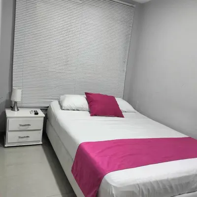 a bedroom with a white bed with a purple blanket at Hotel Casa Bellamare in Cartagena de Indias