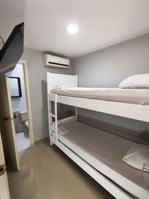 a room with two bunk beds and a bathroom at Hotel Casa Bellamare in Cartagena de Indias