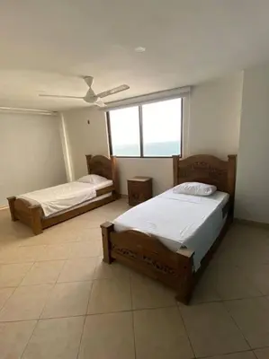 two beds in a room with two windows at Cómodo y acogedor departamento in Cartagena de Indias