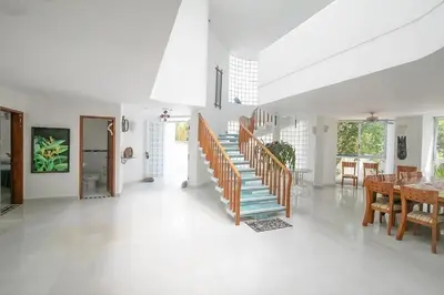 a living room with a staircase and a table and chairs at Cabana Mangle Playa Privada in San Antero