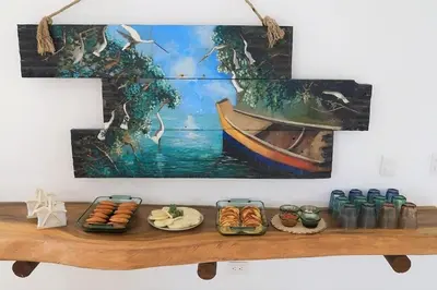 a table with food and a painting of a boat at Cabana Mangle Playa Privada in San Antero