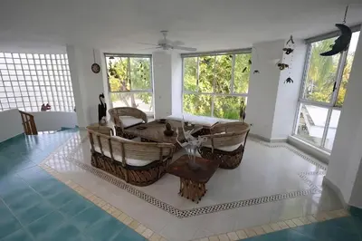 a living room with a table and some windows at Cabana Mangle Playa Privada in San Antero