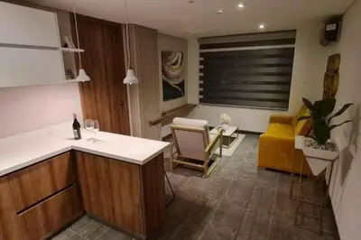 a kitchen and living room with a yellow couch at Fantástico apartamento entero en el norte de la ciudad in Barranquilla