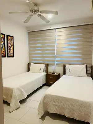 two beds in a bedroom with a ceiling fan at exclusivo edificio con piscina en primera linea de playa in Cartagena de Indias