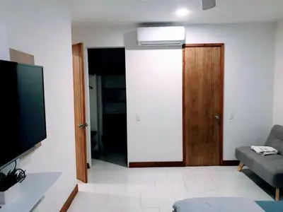 a living room with a television and a door at exclusivo edificio con piscina en primera linea de playa in Cartagena de Indias