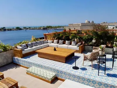 a rooftop patio with couches and a table and chairs at Santa Isabel - Villa de diseño con vistas privilegiadas y piscina in Cartagena de Indias