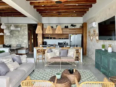 a living room with a couch and a kitchen at Santa Isabel - Villa de diseño con vistas privilegiadas y piscina in Cartagena de Indias