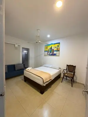 a bedroom with a bed and a chair in it at Casa Hotel La Niña Neyla in Cartagena de Indias