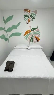 a white bed with two slippers on top of it at Hotel Stay Golden in Cartagena de Indias