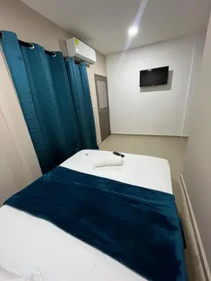 a bedroom with a bed with blue sheets and a tv at Hotel Stay Golden in Cartagena de Indias
