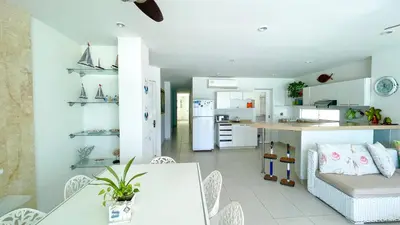 a kitchen and living room with a table and chairs at Hermoso Apartamento Frente al Mar 3 Habitaciones TR12 in Coveñitas