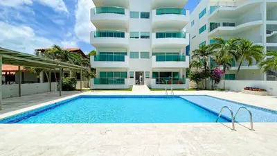 a building with a swimming pool in front of a building at Hermoso Apartamento Frente al Mar 3 Habitaciones TR12 in Coveñitas