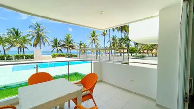 a dining room with a table and chairs and a pool at Hermoso Apartamento Frente al Mar 3 Habitaciones TR12 in Coveñitas