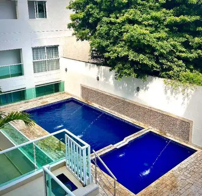 a large blue swimming pool in front of a building at Apartamento Cartagena cerca a la playa in Cartagena de Indias