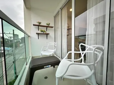 two white chairs sitting on a balcony next to a window at Apartamento Cartagena cerca a la playa in Cartagena de Indias