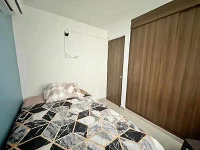 a bedroom with a black and white quilt on a bed at Apartamento Cartagena cerca a la playa in Cartagena de Indias