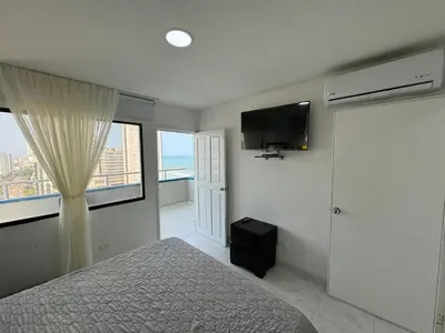 a bedroom with a bed and a flat screen tv at Portofino Bocagrande 2 habitaciones in Cartagena de Indias