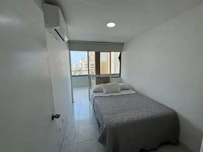 a small bedroom with a bed and a window at Portofino Bocagrande 2 habitaciones in Cartagena de Indias