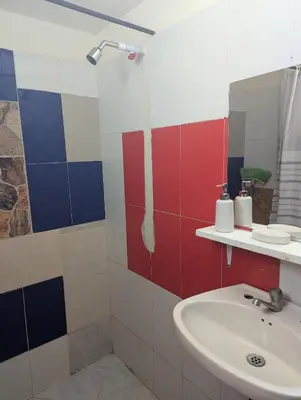 a bathroom with red white and blue tiles at Casa Victoria in San Onofre