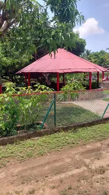 a pavilion with a red roof in a park at Cabaña Villa Gabi in San Antero