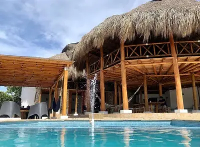 a resort with a swimming pool and a straw hut at La Mofa Beach House in Bocachica