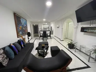a living room with a black couch and a table at Espectacular apartamento de 4 alcobas en el Laguito in Cartagena de Indias
