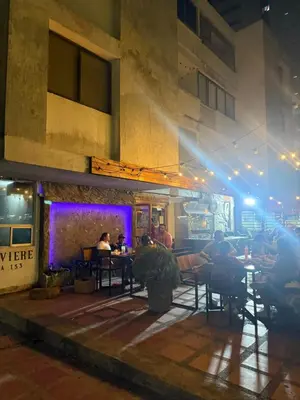 people sitting at tables in a restaurant at night at Espectacular apartamento de 4 alcobas en el Laguito in Cartagena de Indias