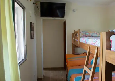 a small bedroom with a bunk bed and a window at Alojamiento Familiar #4 - El mejor mar y playas in Puerto Viejo