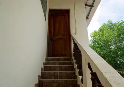 a wooden door on the side of a building with stairs at Alojamiento Familiar #4 - El mejor mar y playas in Puerto Viejo