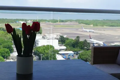 a vase of red tulips on a table with an airport at Cartagena Aparta Suite Crespo Aeropuerto in Cartagena de Indias