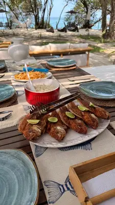 a table with plates of food on top at Casa Rosario in Isla Grande