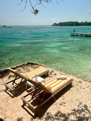 two lounge chairs on a beach near the water at Casa Rosario in Isla Grande