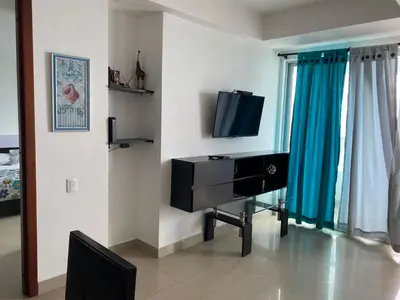 a living room with a tv and a desk at Apartamento Palmetto en Cartagena Vista al mar 702 in Cartagena de Indias