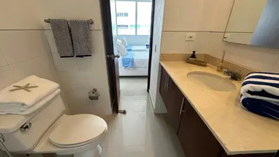 a bathroom with a toilet and a sink and a mirror at Apartamento con salida y vista a la playa in Cartagena de Indias