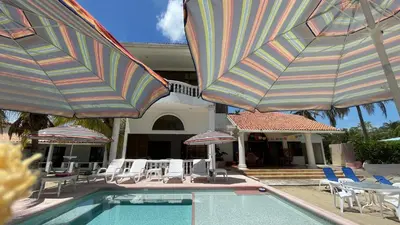 a pool with umbrellas and chairs and tables and chairsktop at Casa frente a la playa, San Antero Cordoba in San Antero
