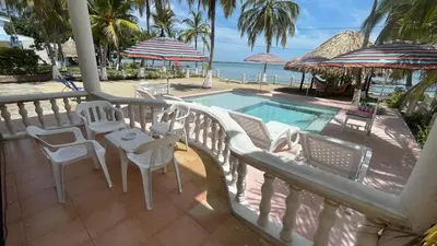 a balcony with a table and chairs and a swimming pool at Casa frente a la playa, San Antero Cordoba in San Antero