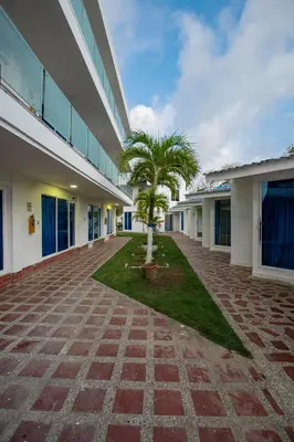 a courtyard with two palm trees in front of a building at Hotel Be Real in Coveñitas
