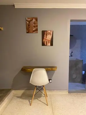 a white chair sitting next to a wall with paintings at Casa Piedra Barranquilla in Barranquilla