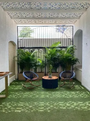 two chairs and a table in a room with plants at Casa Piedra Barranquilla in Barranquilla