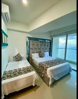 a bedroom with two beds and a large window at Palmetto Eliptic in Cartagena de Indias
