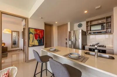 a kitchen with a counter with chairs and a counter top at Frente al Mar, con playa y 4 piscinas en Cartagena in Cartagena de Indias