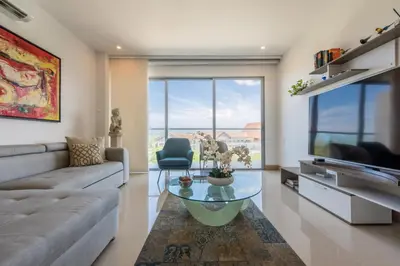 a living room with a couch and a glass coffee table at Frente al Mar, con playa y 4 piscinas en Cartagena in Cartagena de Indias