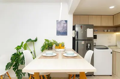 a kitchen with a table with chairs and a refrigerator at Apartamento frente al mar, vista al centro de Cartagena in Cartagena de Indias
